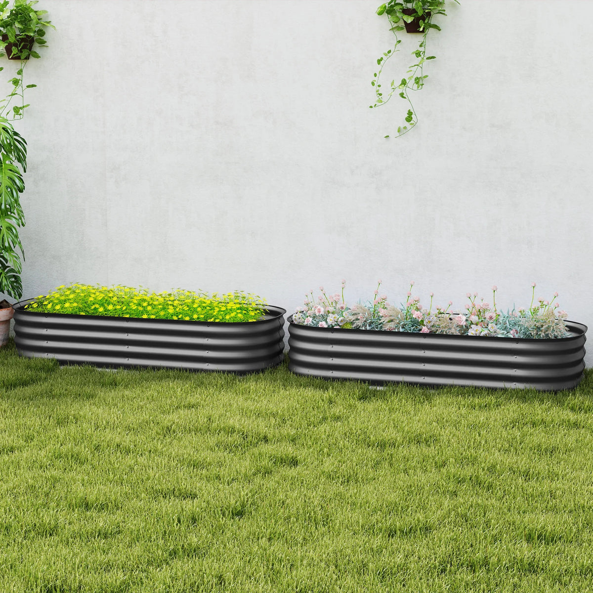 Two dark grey raised garden beds with safety edging, plants inside on grass
