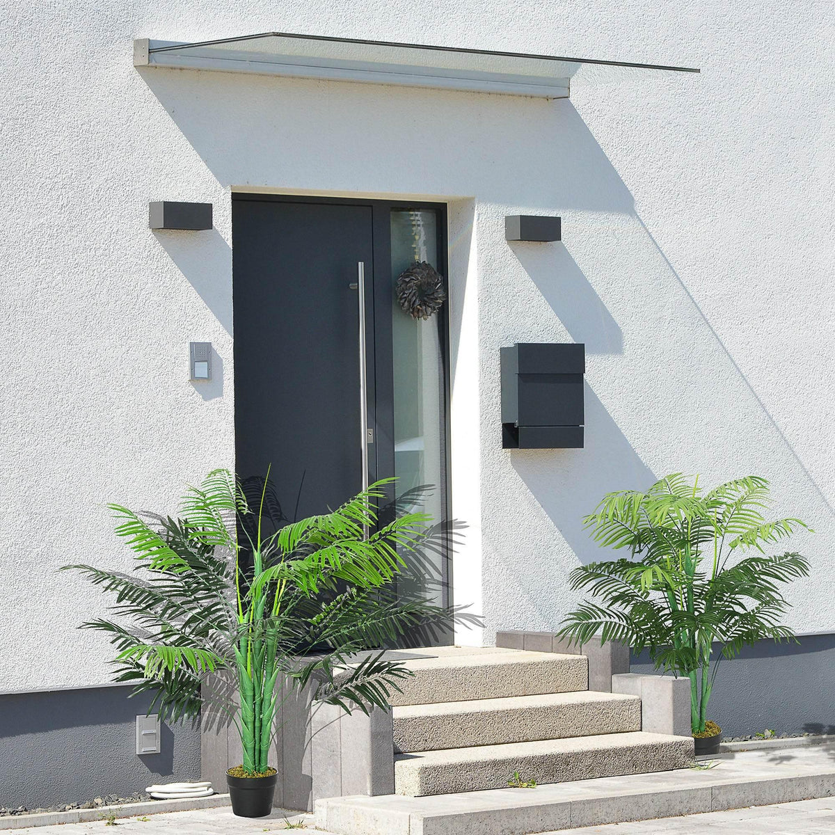 Pair of artificial palm trees in black pots with lush green faux fronds for decor
