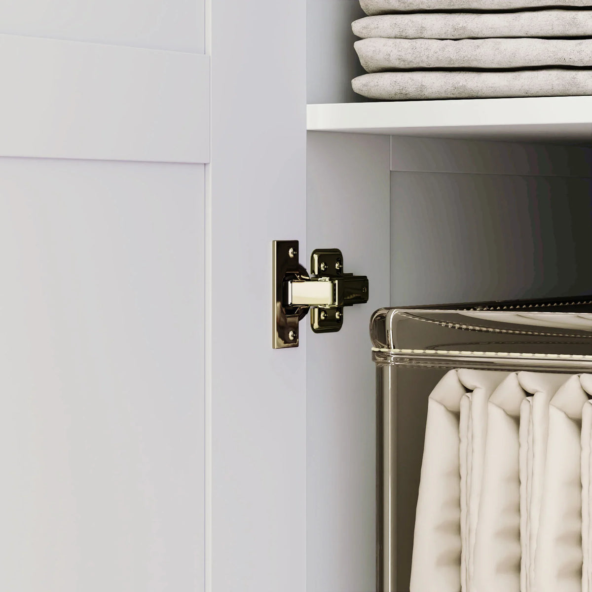 White wardrobe door hinge and latch hardware near folded clothes storage