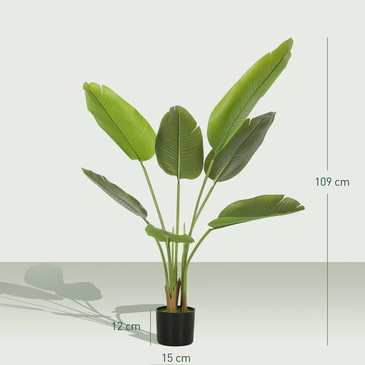 Artificial bird of paradise plant in black pot, tall stems with broad green leaves