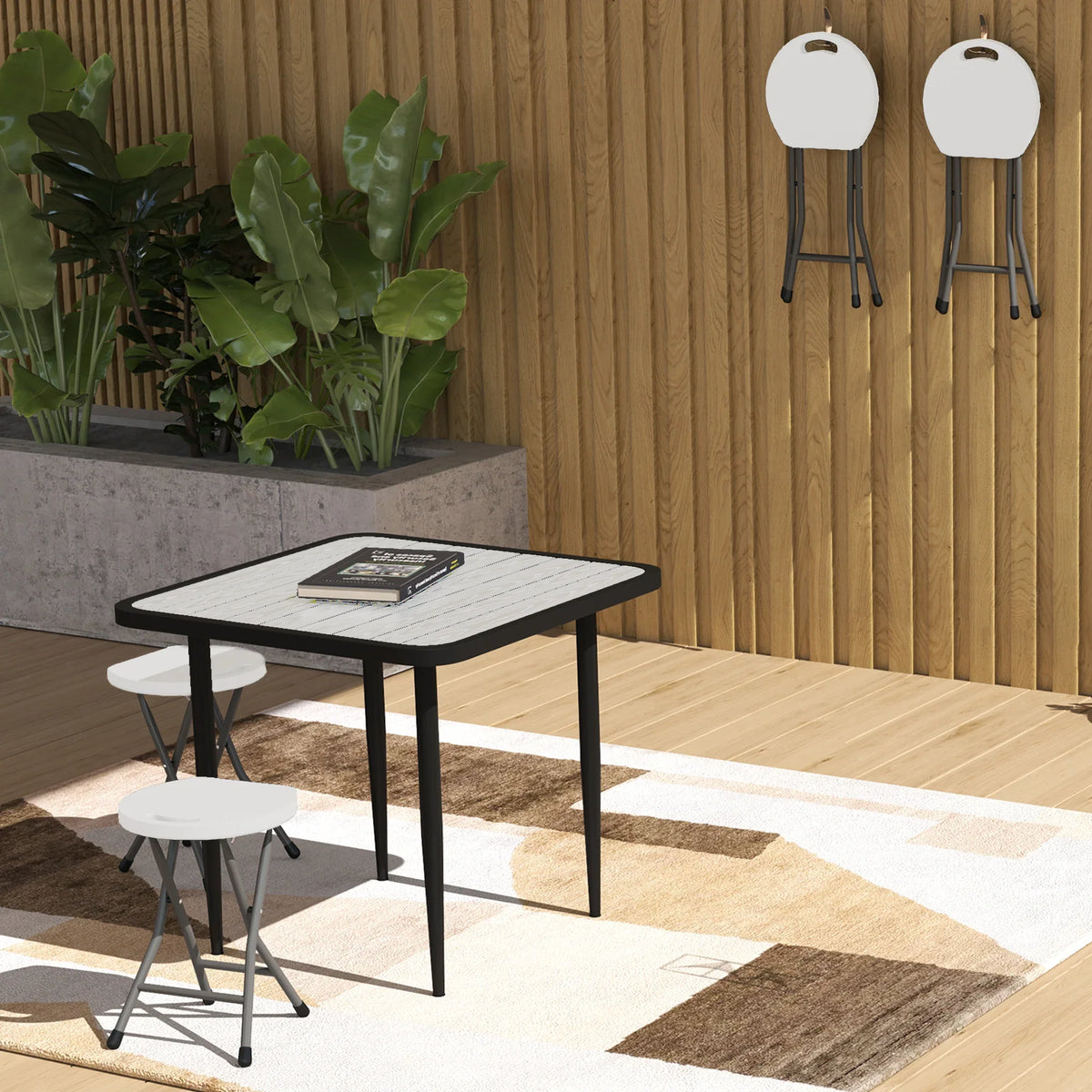 White folding stool with round seat and cross-braced black metal legs