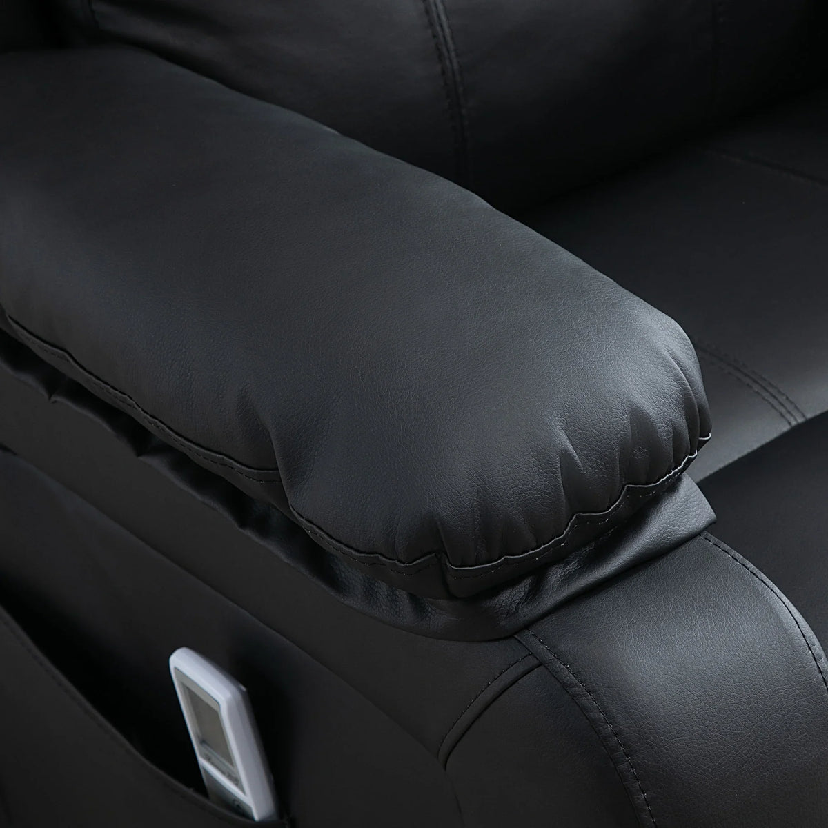 Close-up of black PU power lift recliner arm and stitched seat cushion