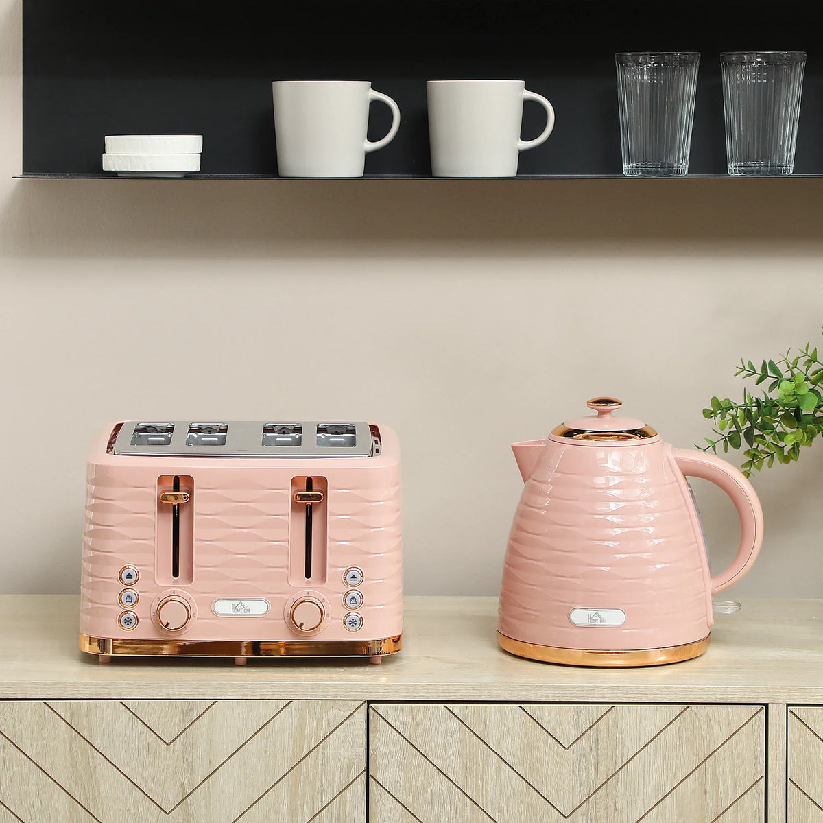 Pink 4-slice toaster and electric kettle set on a countertop ledge