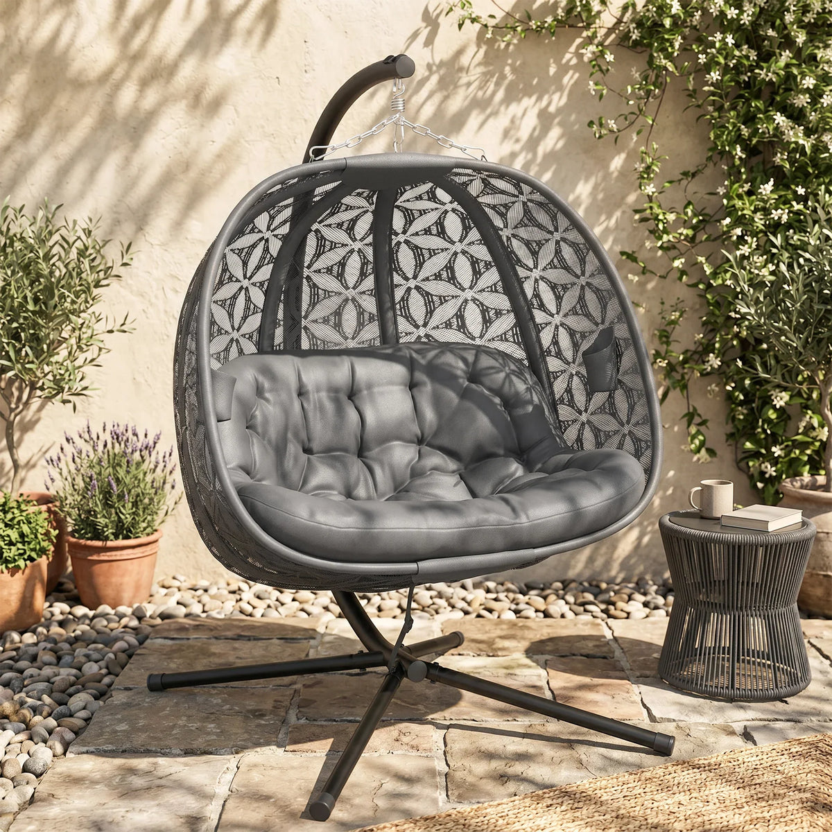 Charcoal double hanging patio chair with gray tufted cushion and leaf-patterned shell
