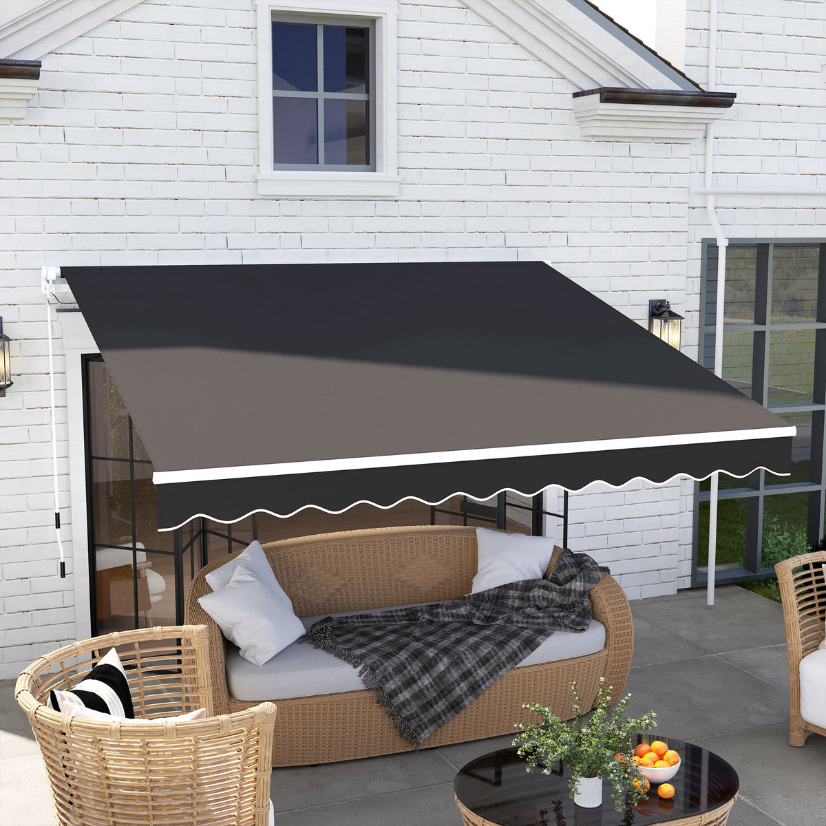 Black manual retractable patio awning with scalloped valance over seating area