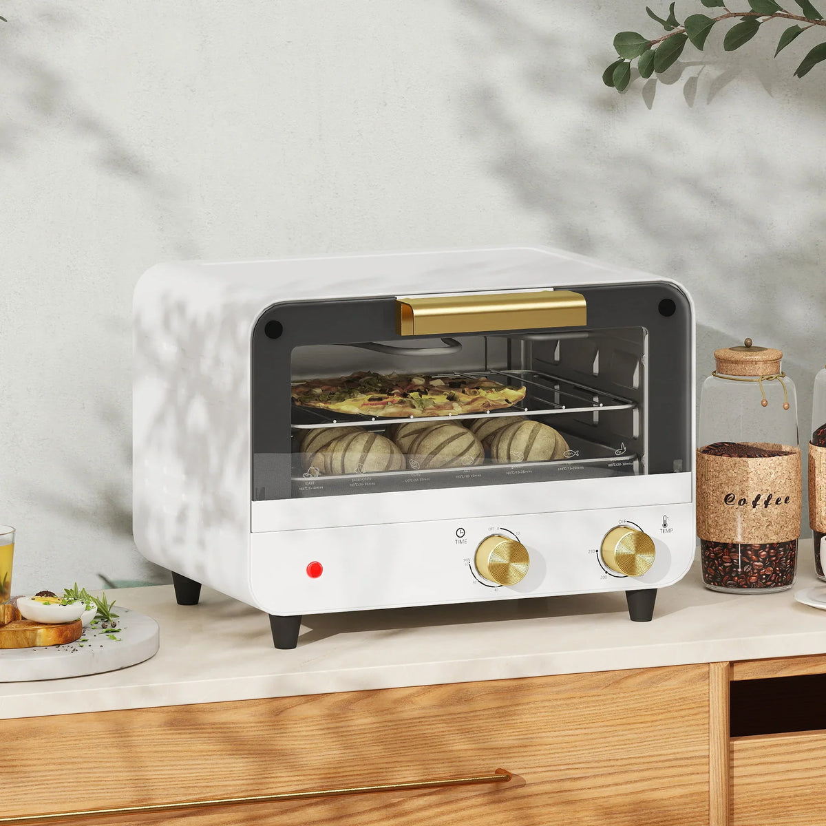 White countertop toaster oven with glass door, front knobs, and visible baking chamber