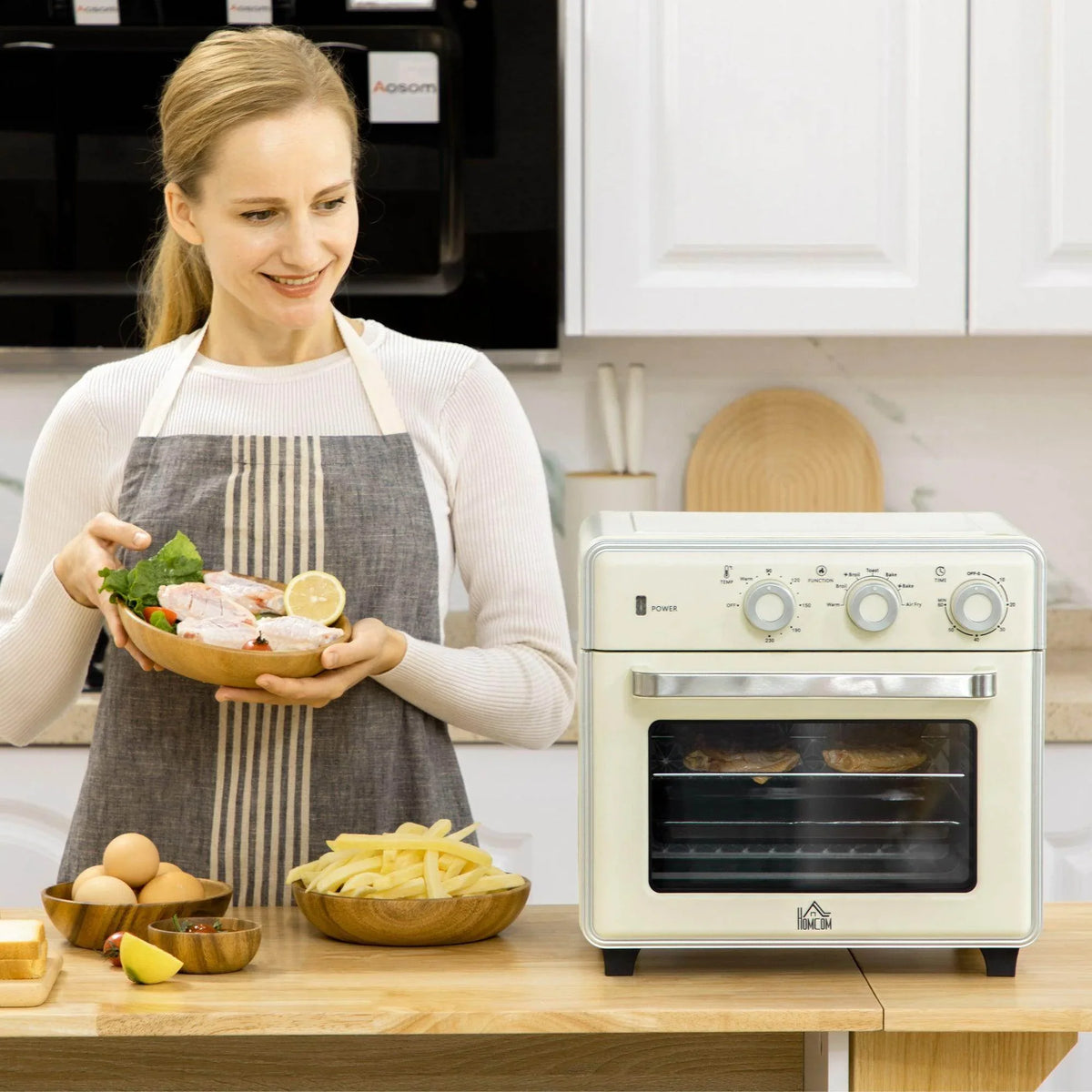 Cream 4-slice toaster oven with three round control knobs on a kitchen counter