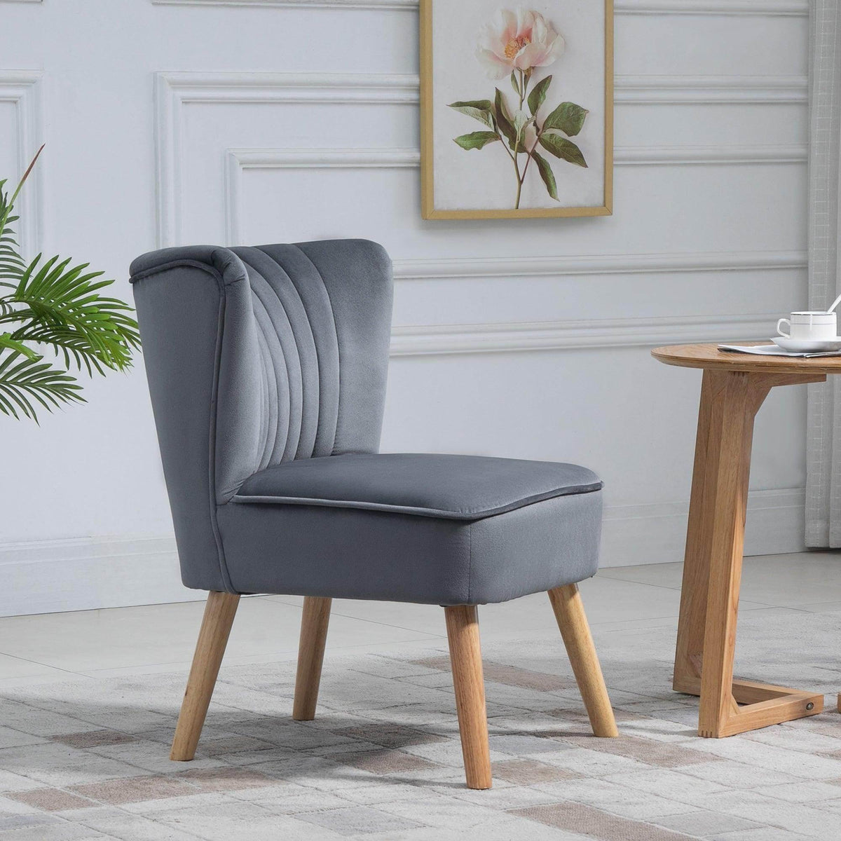 Grey velvet tub chair with channel-tufted backrest, armrests, and wooden legs