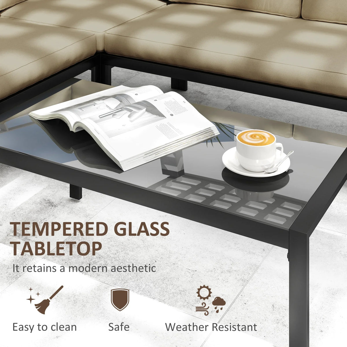 Glass-top outdoor table on black metal legs with open magazine on top