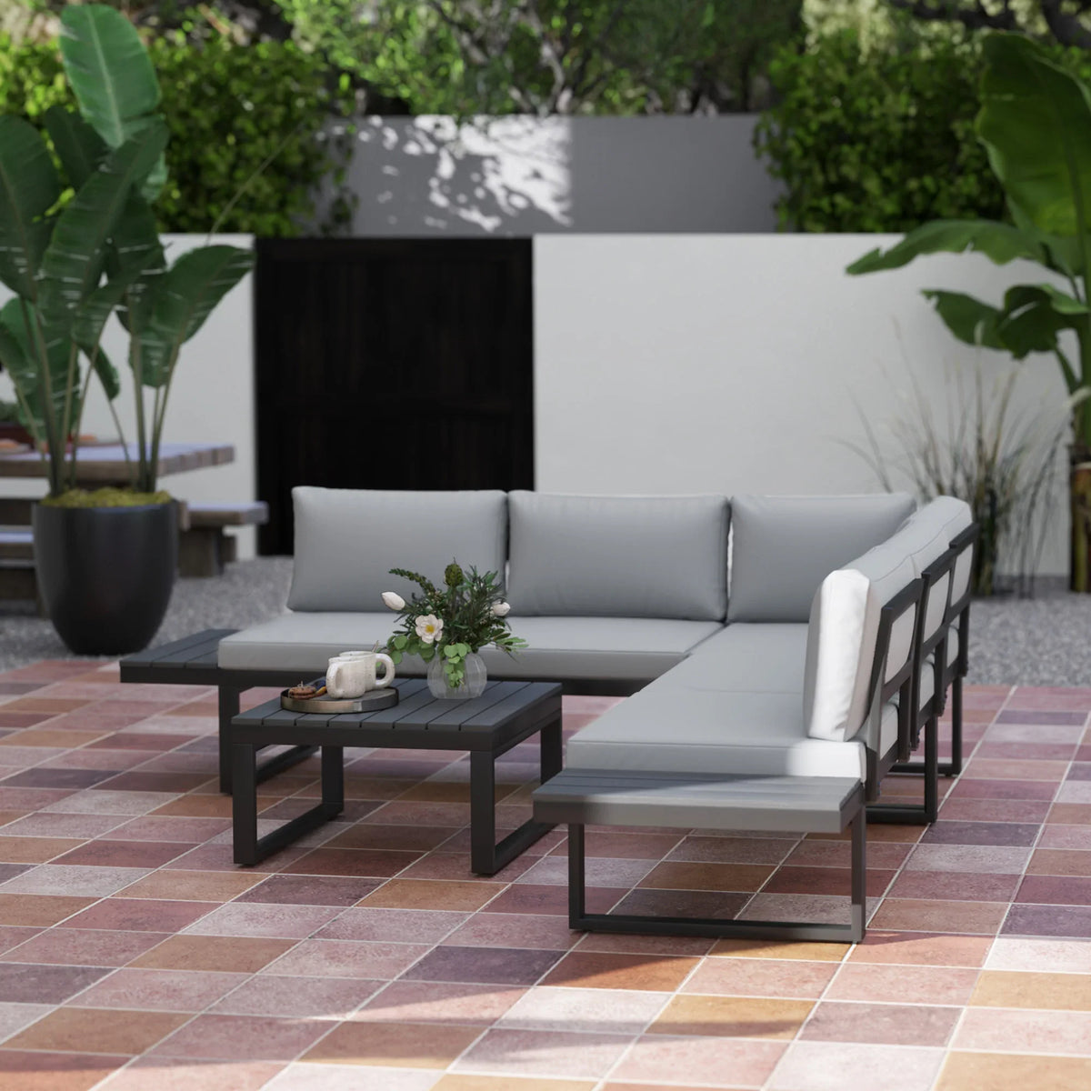 Outdoor corner sofa set with light gray cushions and black frame, with square coffee table.
