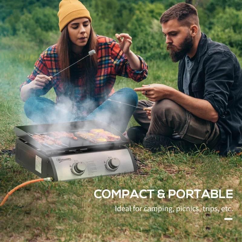 Compact portable tabletop gas plancha grill on grass with two burner controls