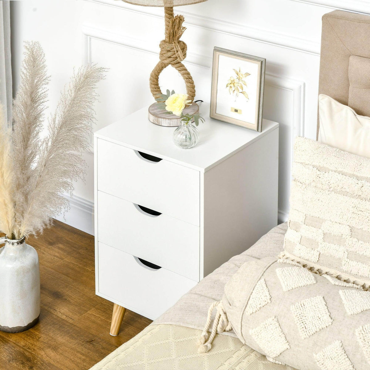 White 3-drawer chest with black curved handles, with lamp and decor on top