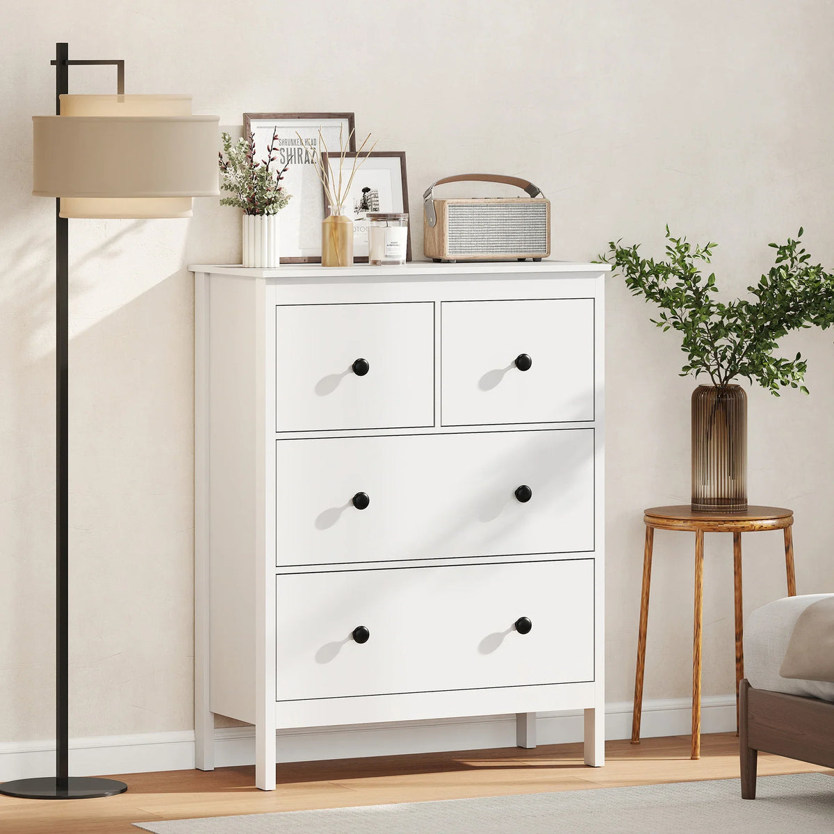 White 4-drawer chest of drawers with black round knobs and open side panels