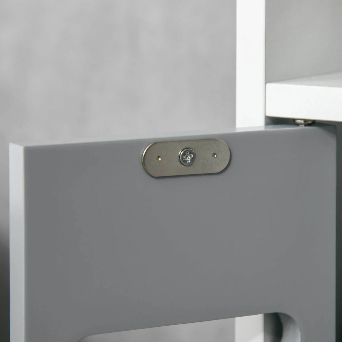 Grey bathroom cabinet door with oval metal handle plate and central screw detail