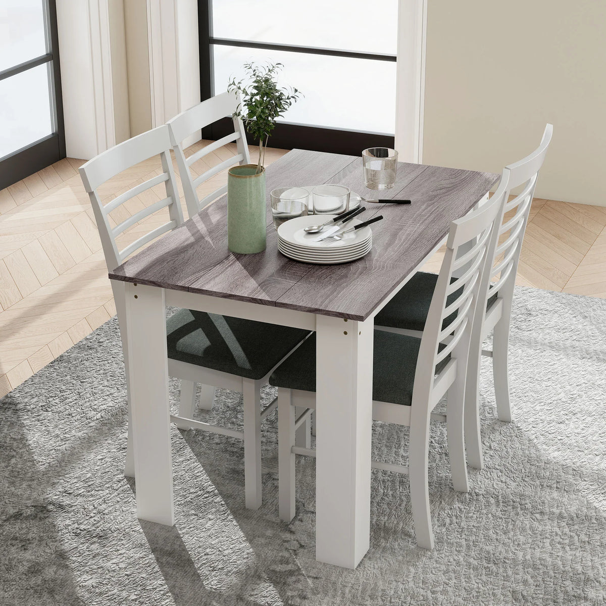 Grey wood-effect dining table with white base and chairs set up for dining