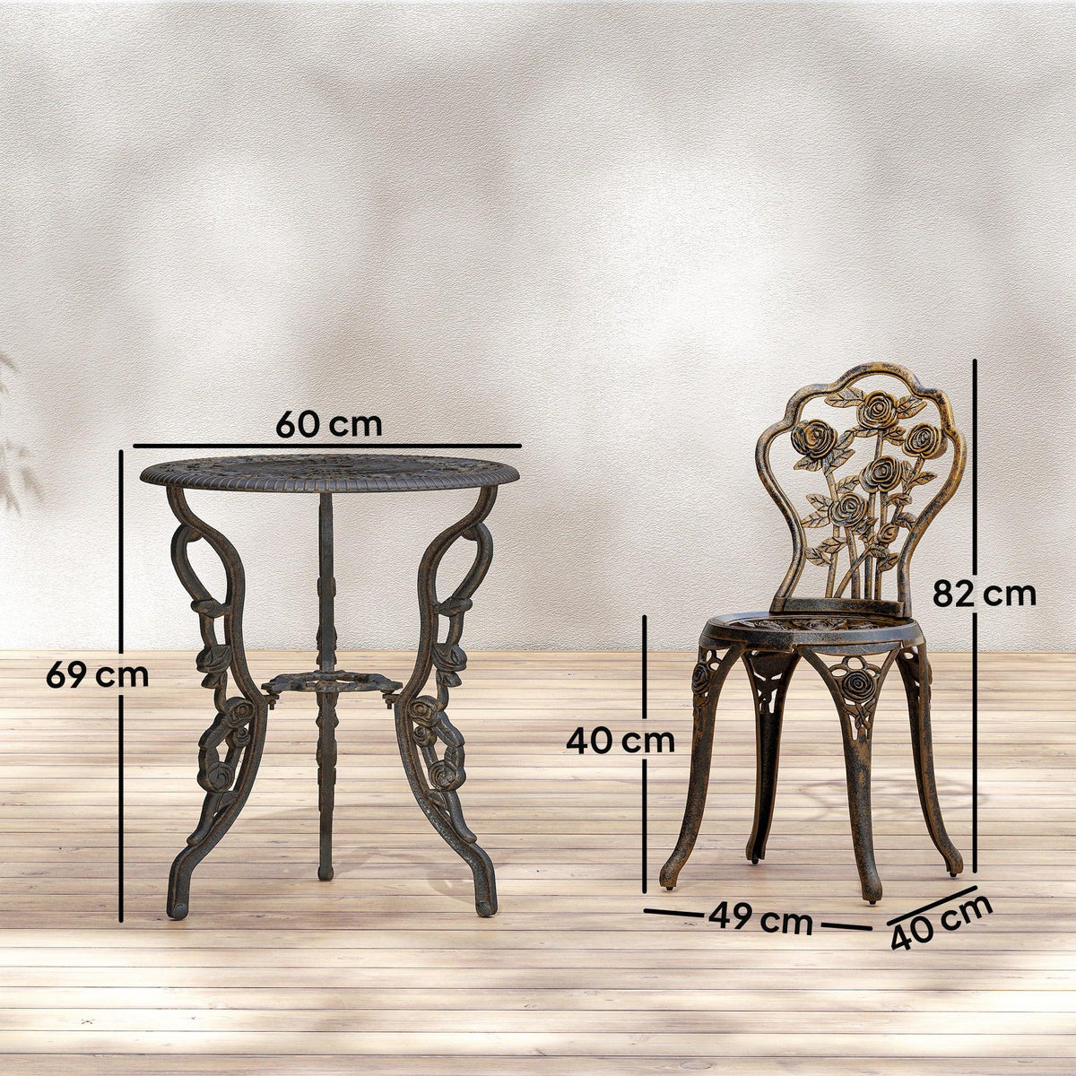 Bronze round bistro table with umbrella hole and two ornate chairs with decorative backs.
