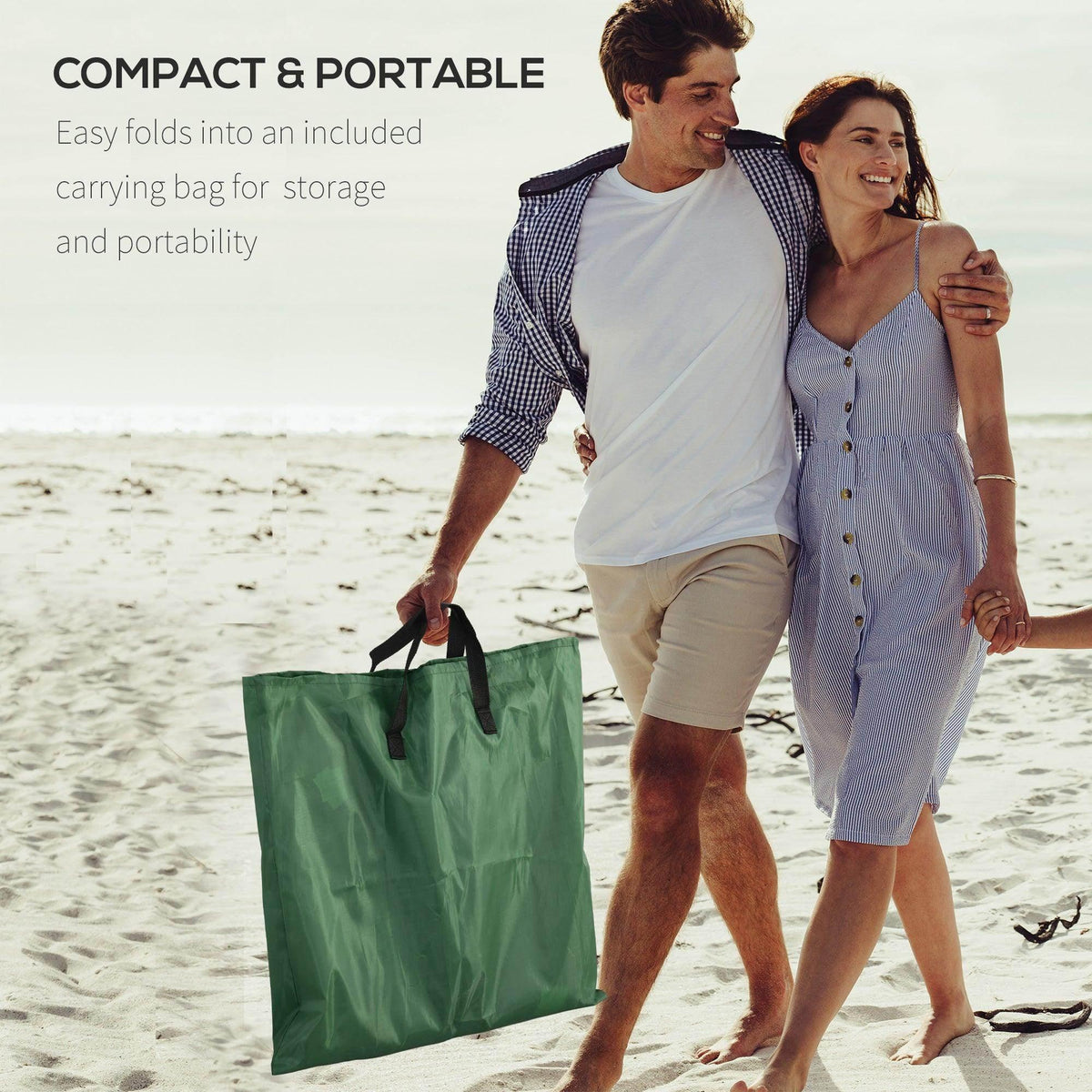 Green reclining chair beside a large carrying bag for compact storage at the beach
