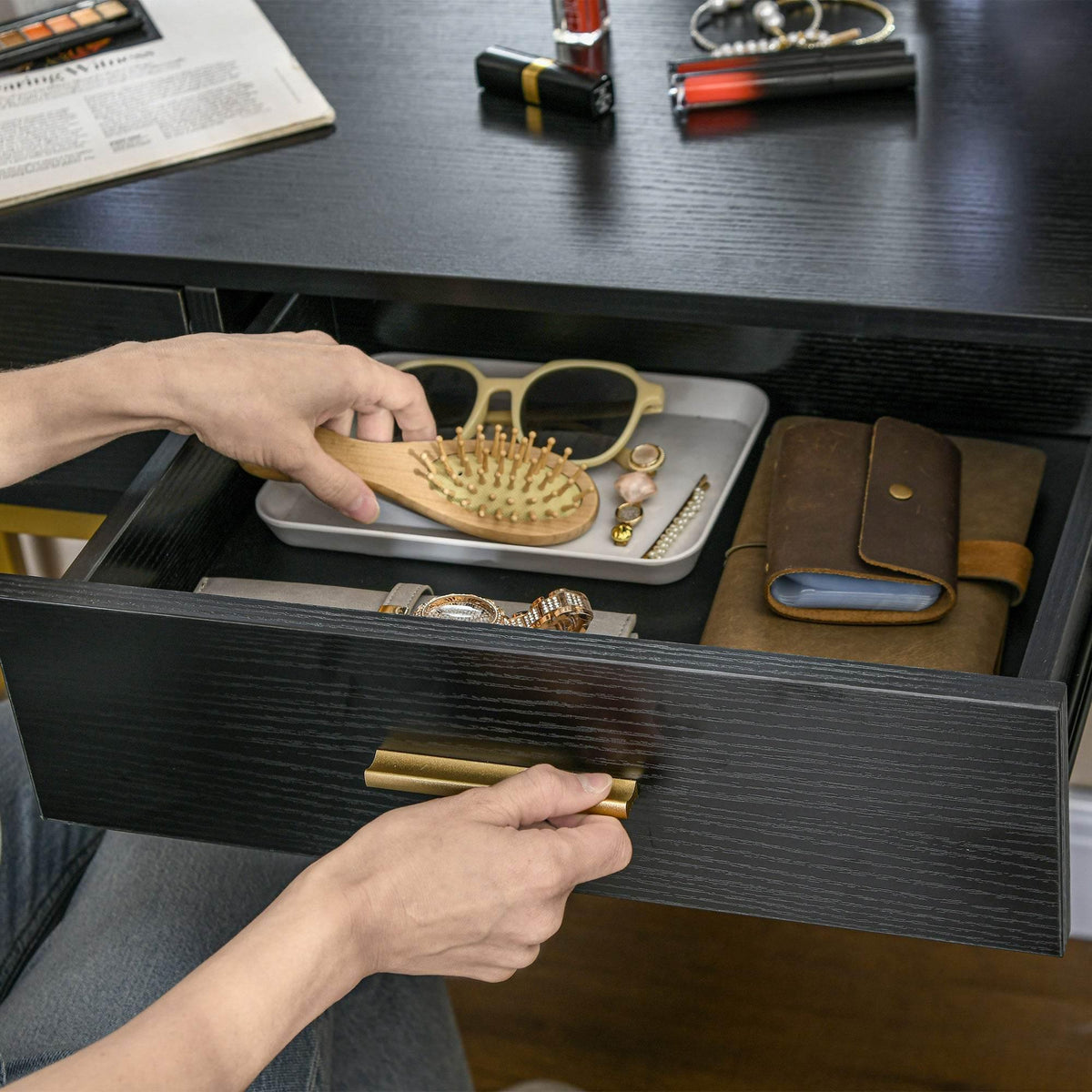 Open black vanity drawer with organizer dividers for combs and jewelry accessories
