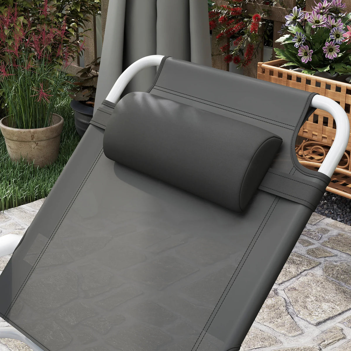 Charcoal grey padded headrest and seat on foldable outdoor lounge chair with white frame