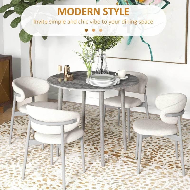 Grey round drop-leaf dining table in a modern dining room with surrounding chairs