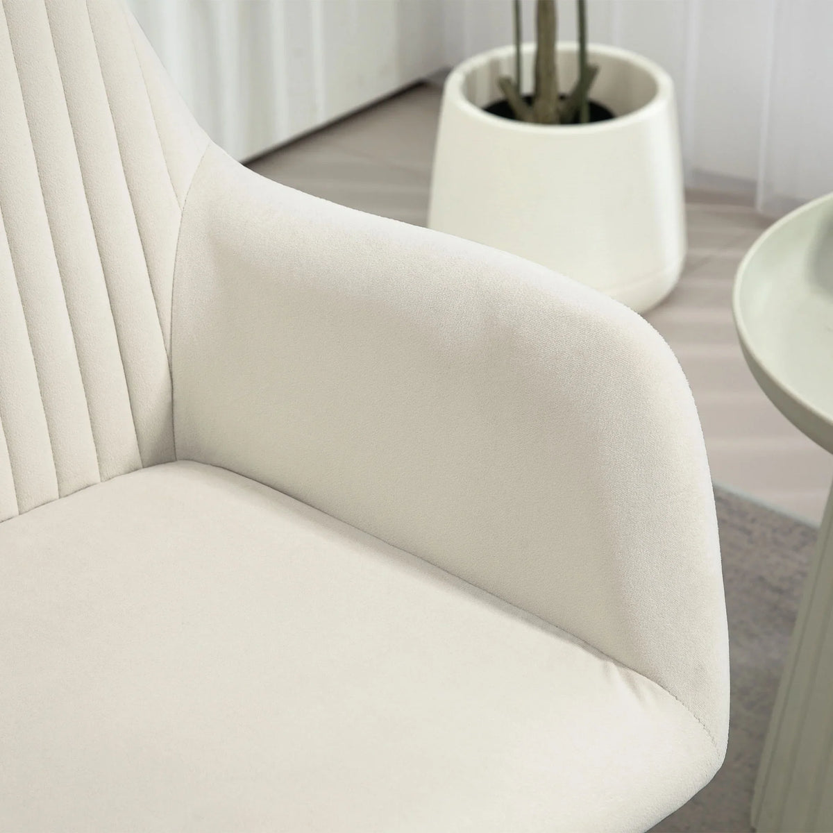 Cream accent arm chair close-up of curved arm and upholstered seat cushion