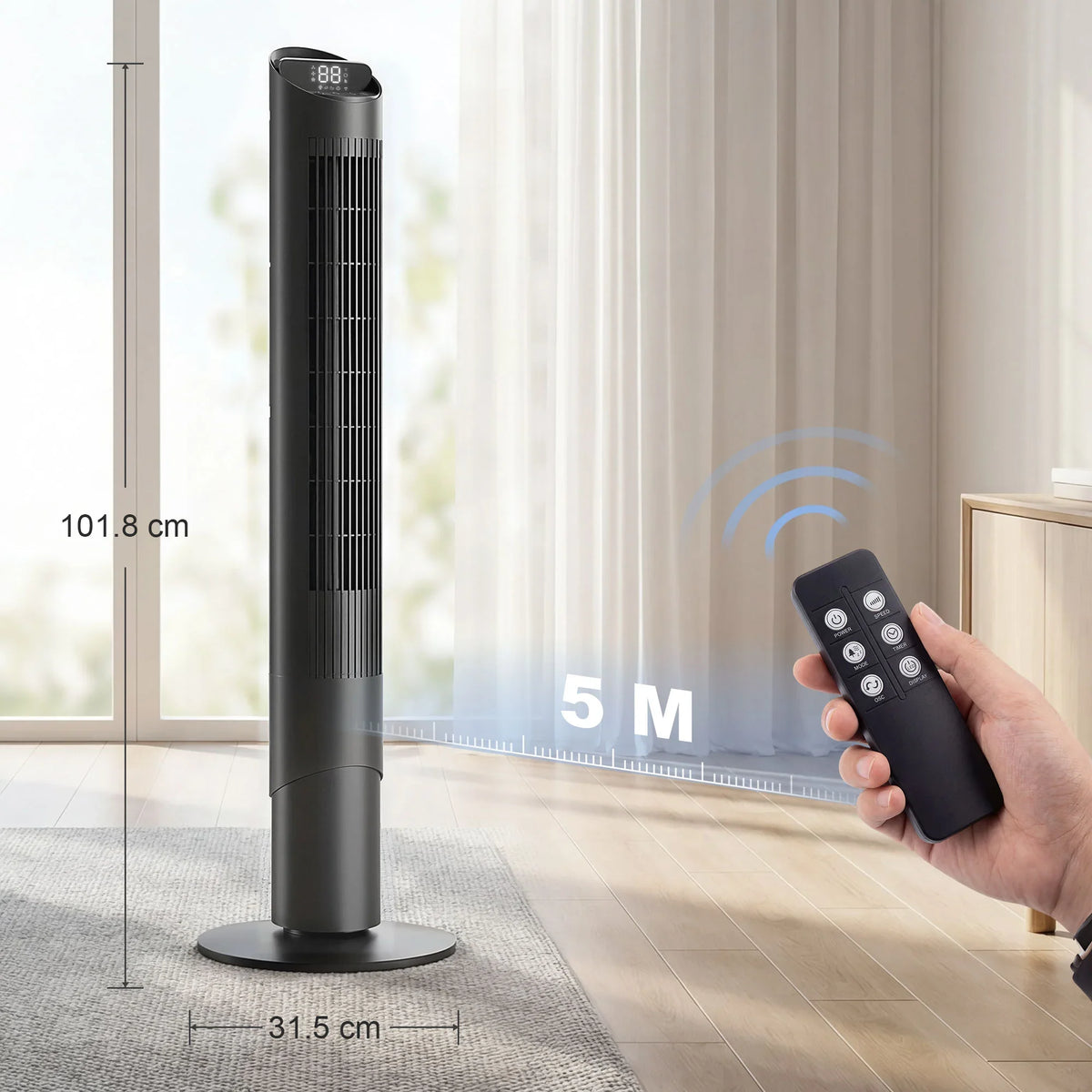 Black tower fan on floor with remote in hand, showing fan size
