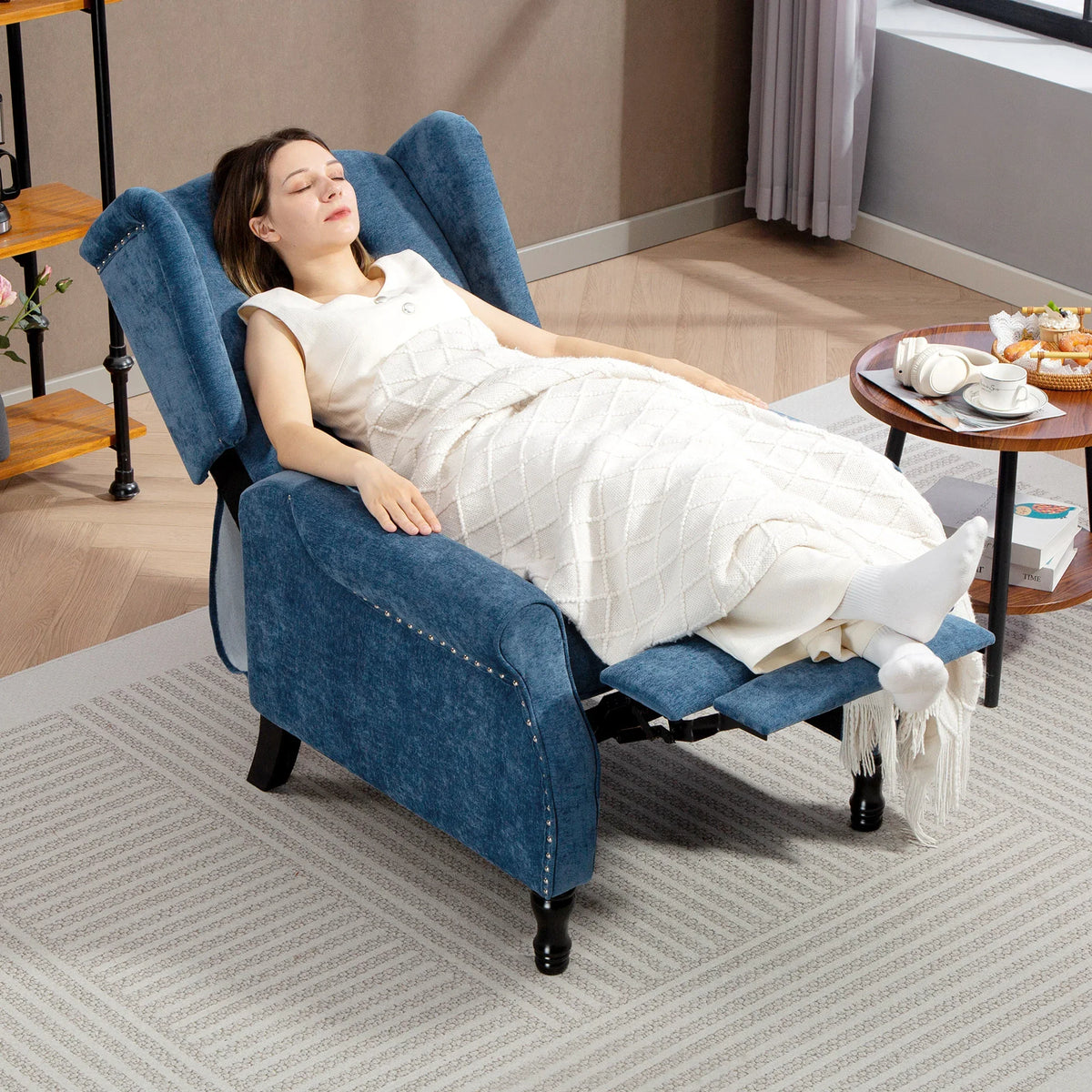 Royal blue reclining armchair with footrest, person lounging with legs extended