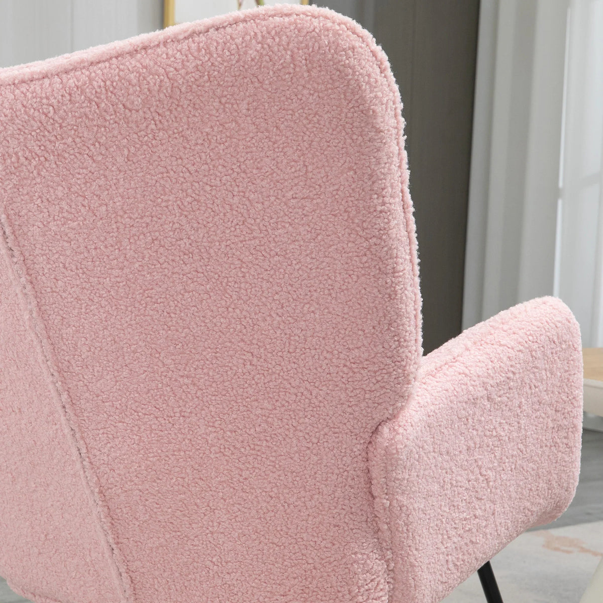 Pink plush wingback chair armrest and high back, textured upholstery