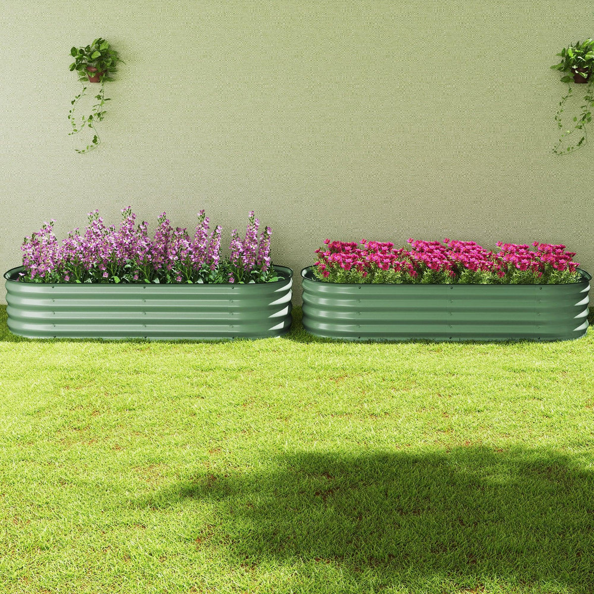 Two green metal raised garden beds with safety edging, filled with purple and pink flowers