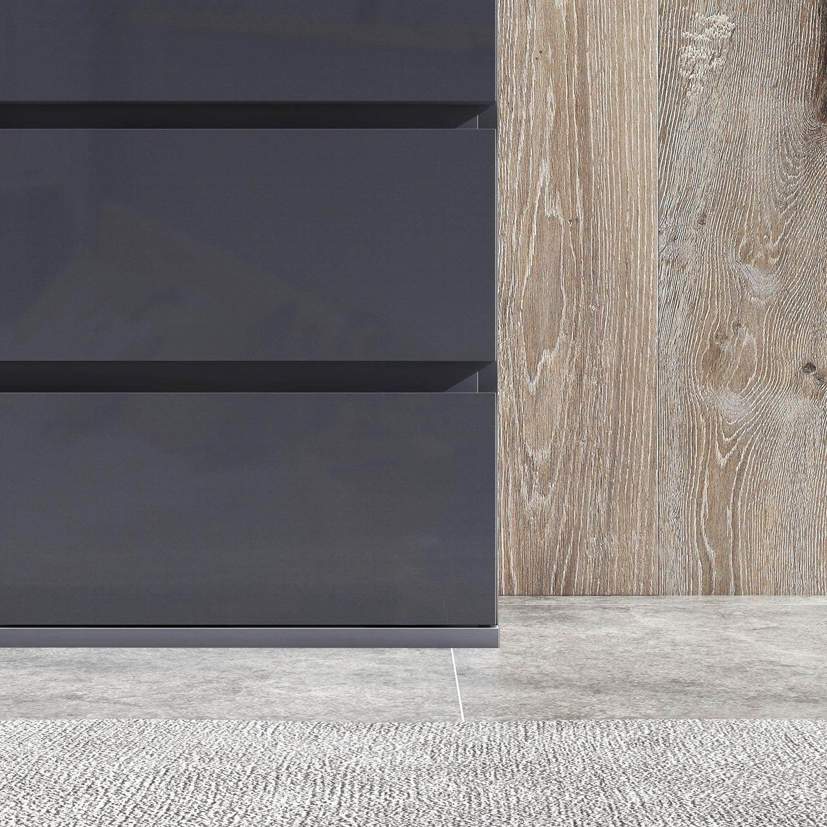 Bottom view of dark gray 4-drawer dresser with non-slip foot pads on floor