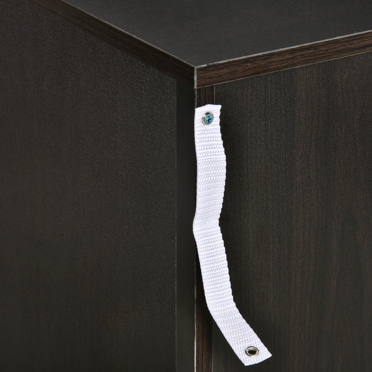Anti-tip strap attached to the corner of a black bedside table.