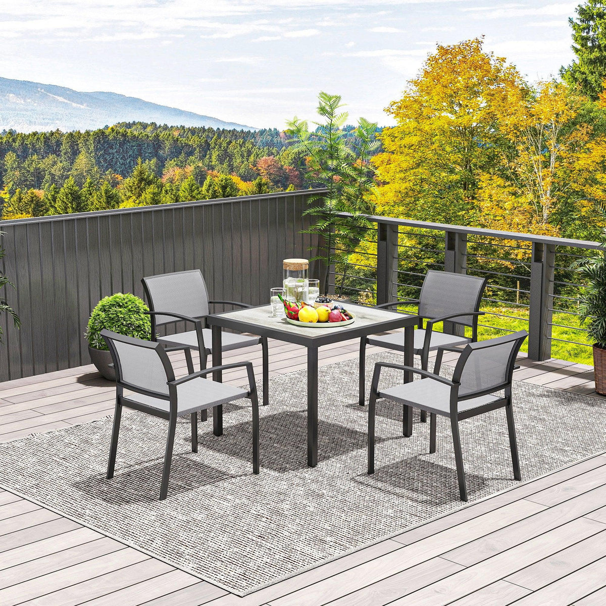 Outdoor dining set on deck with square grey table and four grey armchairs