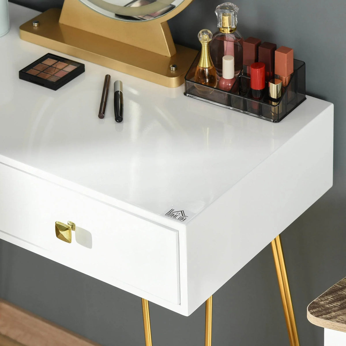 White vanity tabletop and drawer front with mirror base and gold-tone decorative organizer