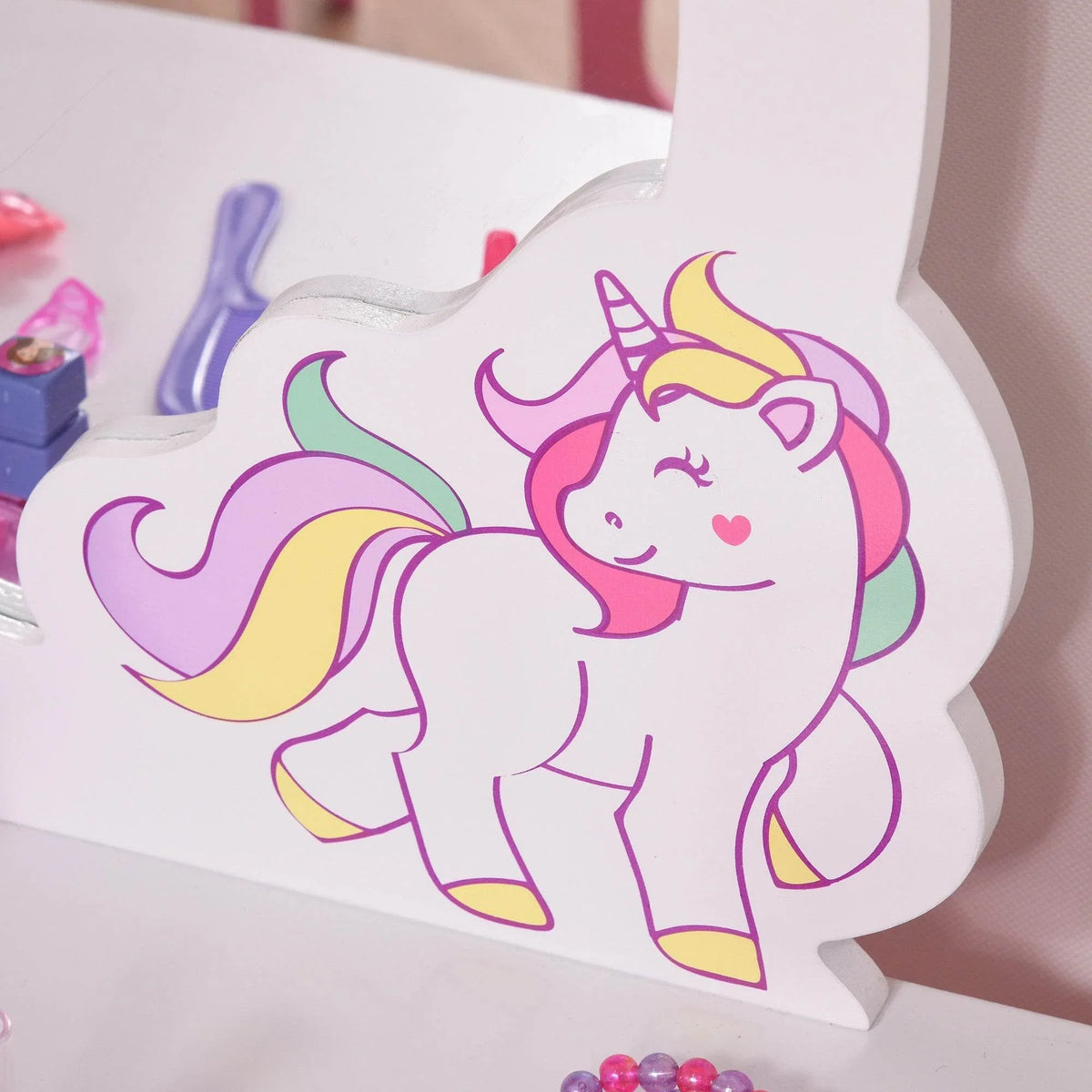 Pink-and-white vanity tabletop with unicorn decal on oval mirror frame
