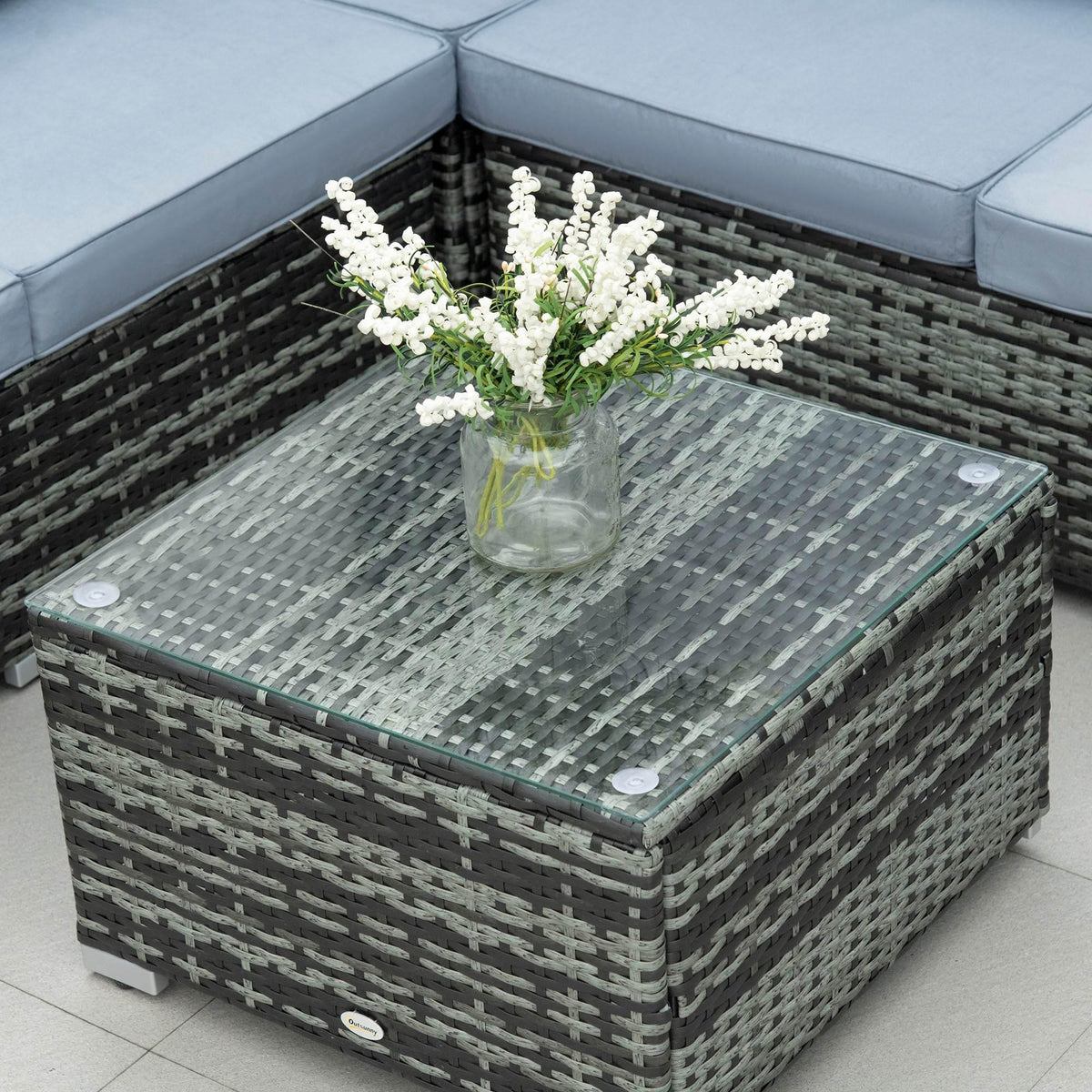 Grey rattan coffee table with tempered glass top and bouquet centerpiece