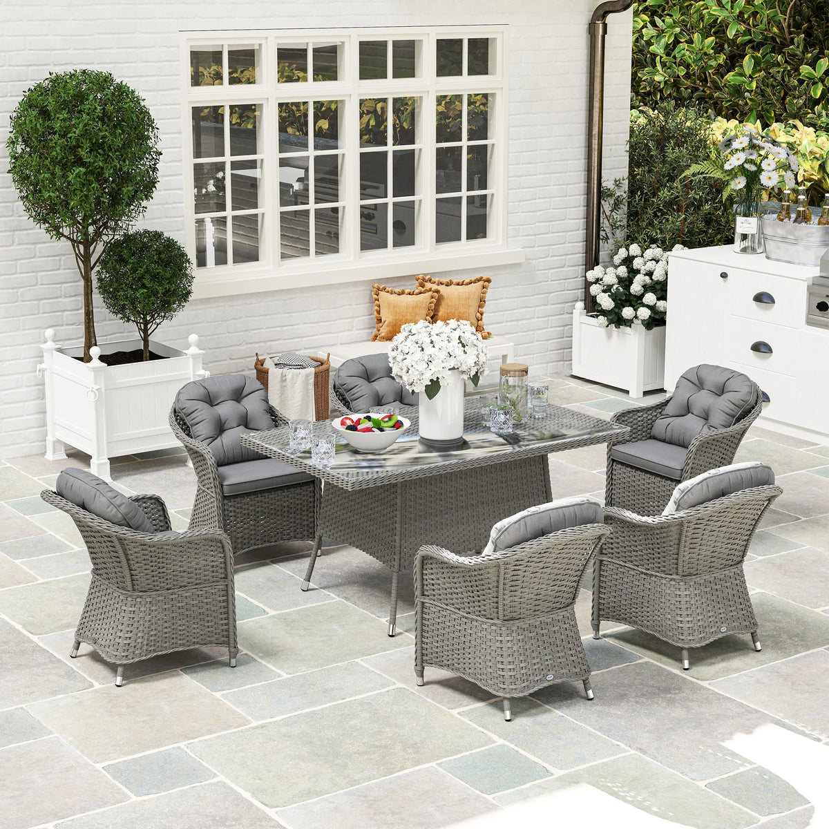 Light grey rattan dining set with glass-top table and six grey armchairs