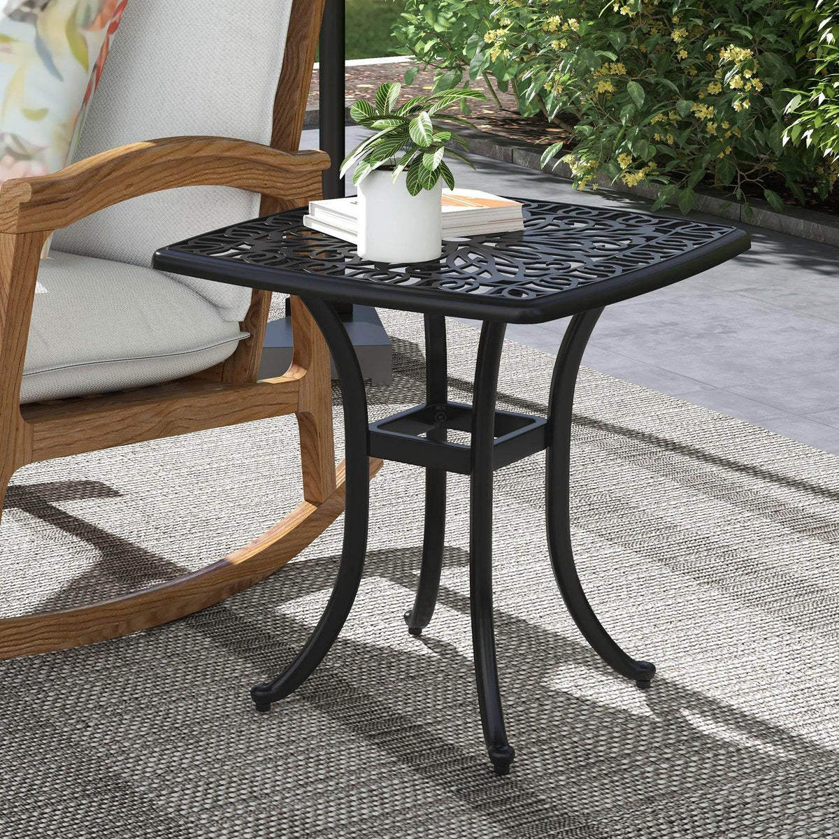Black cast aluminum square bistro table with decorative lattice top and four curved legs