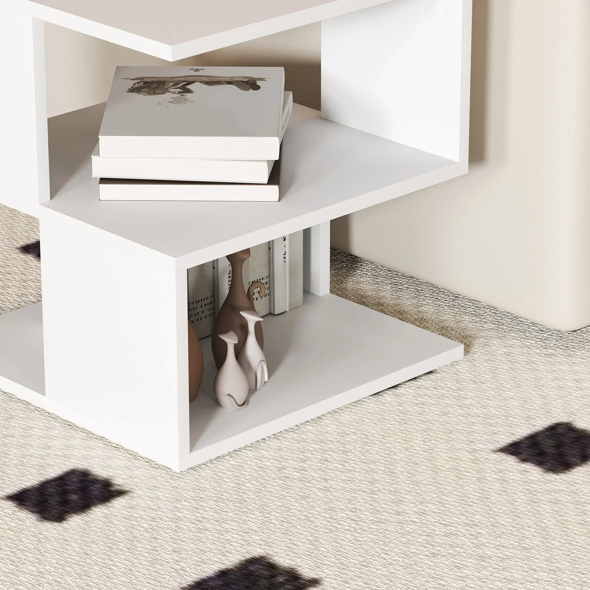 White square side table lower open shelf showing stacked books and small vases.