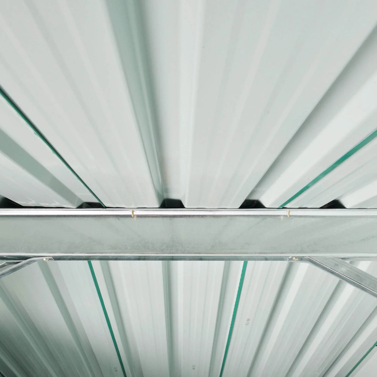 Metal shed roof interior view with white paneling and green support beams