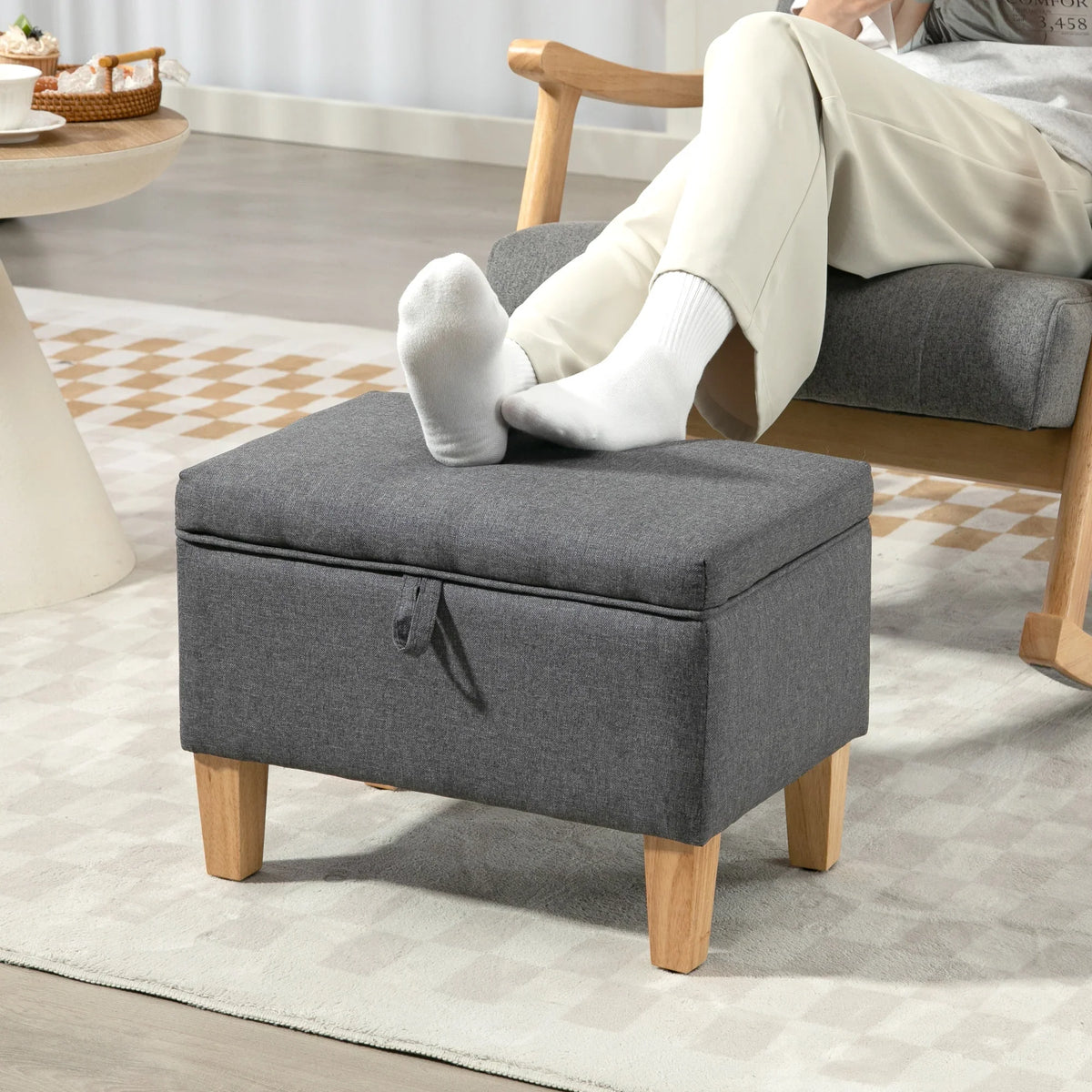 Charcoal grey upholstered storage ottoman with padded seat and front tie detail