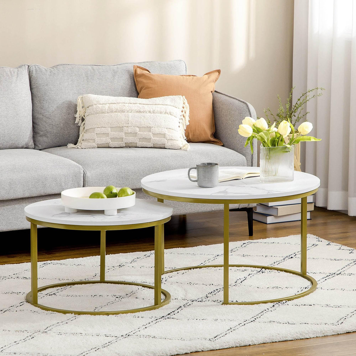 Round nesting coffee table set with white faux marble tops and gold metal frames