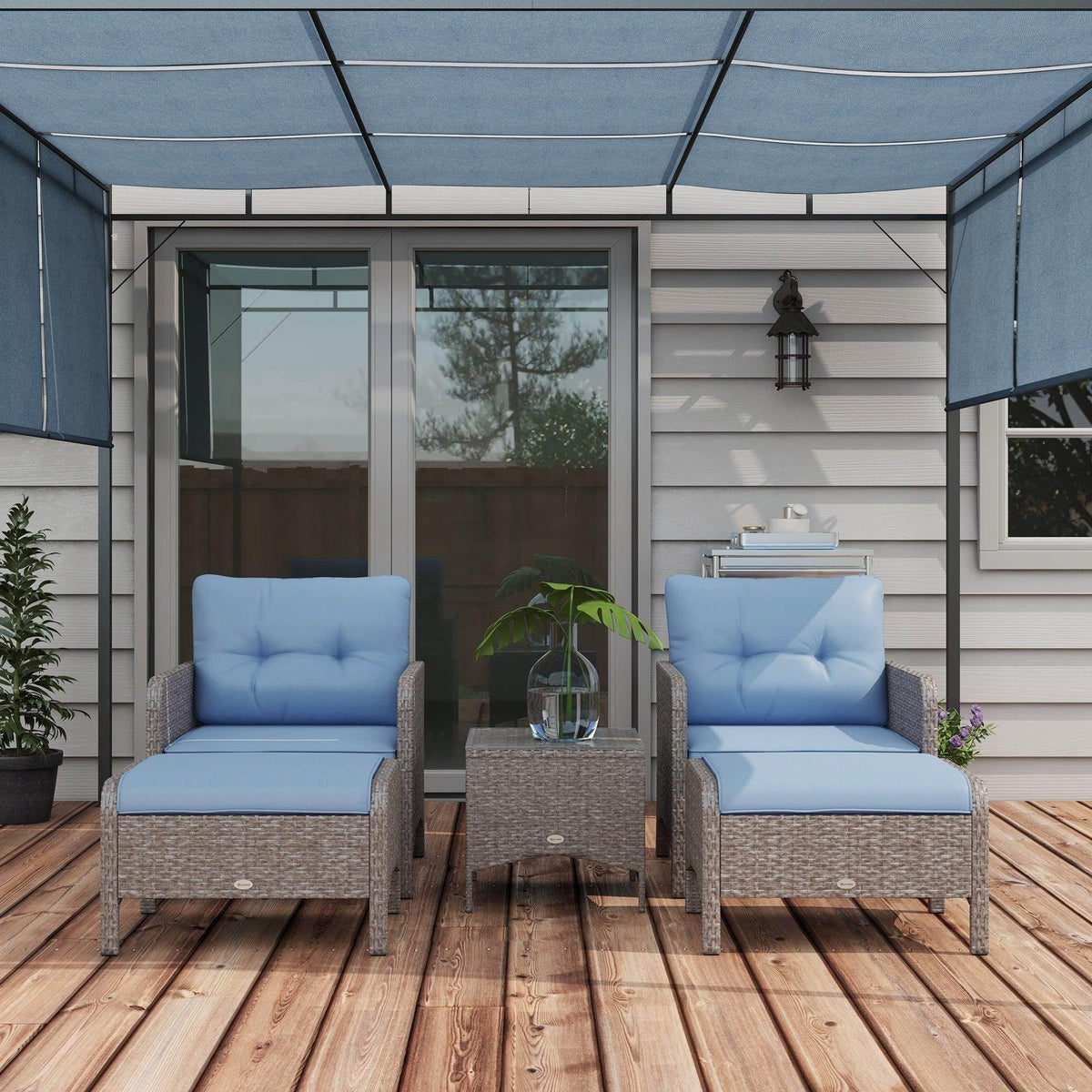 Two outdoor armchairs with gray PE rattan sides and blue cushions, with center glass tabletop