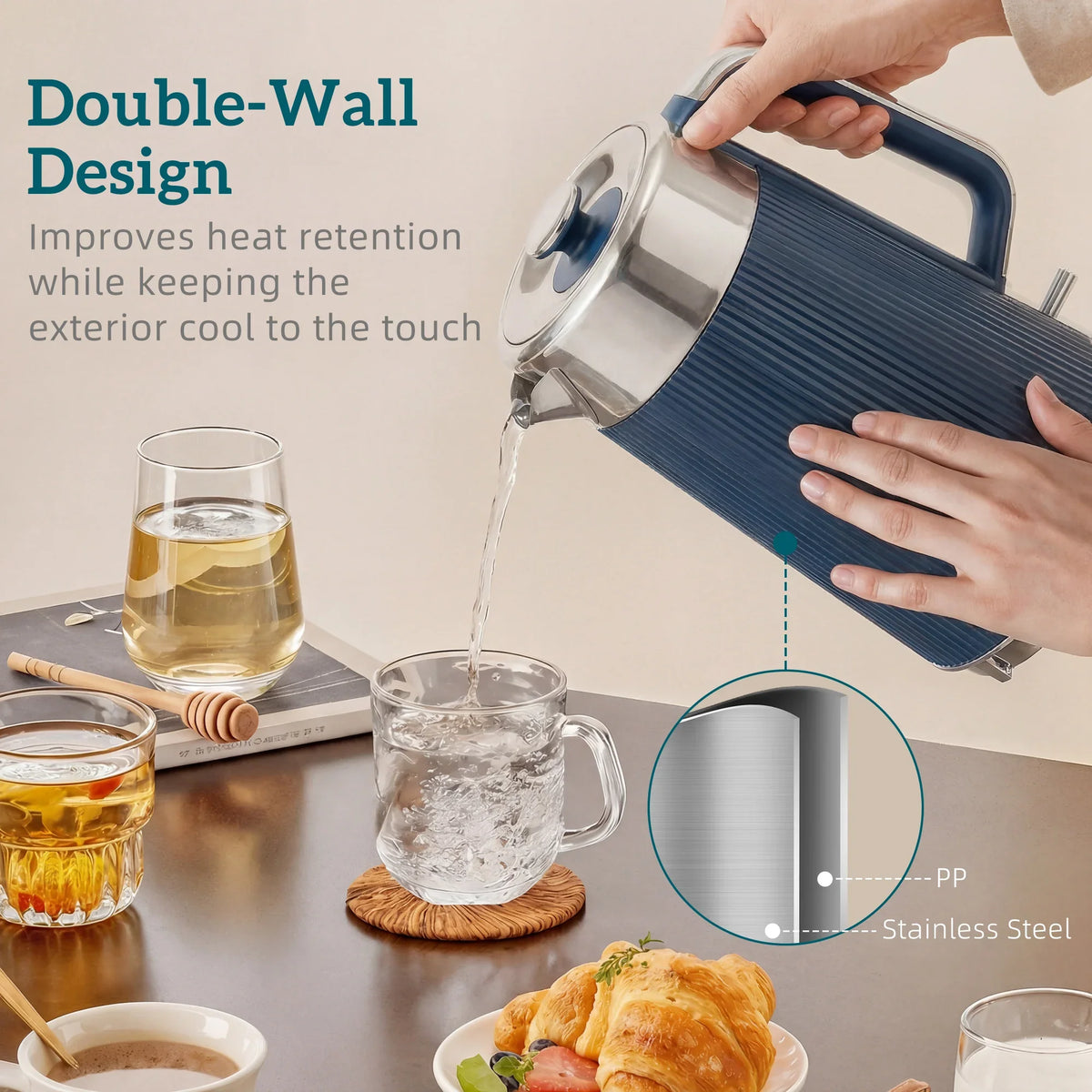 Dark blue electric kettle pouring into a glass cup, showing stainless steel body