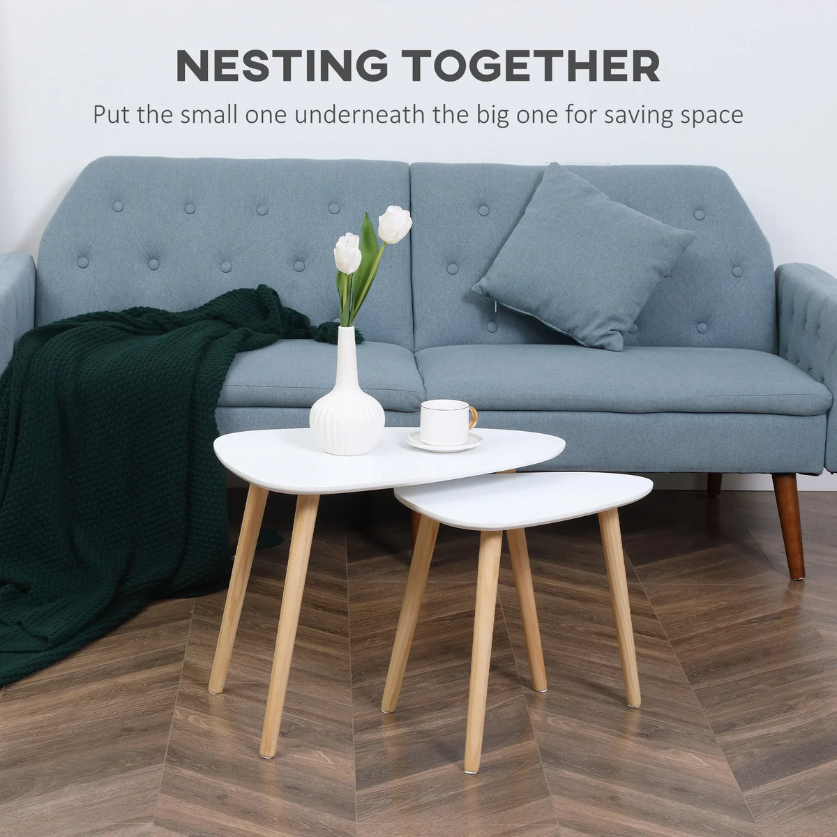 Two nesting round coffee tables with white tops and light wood legs