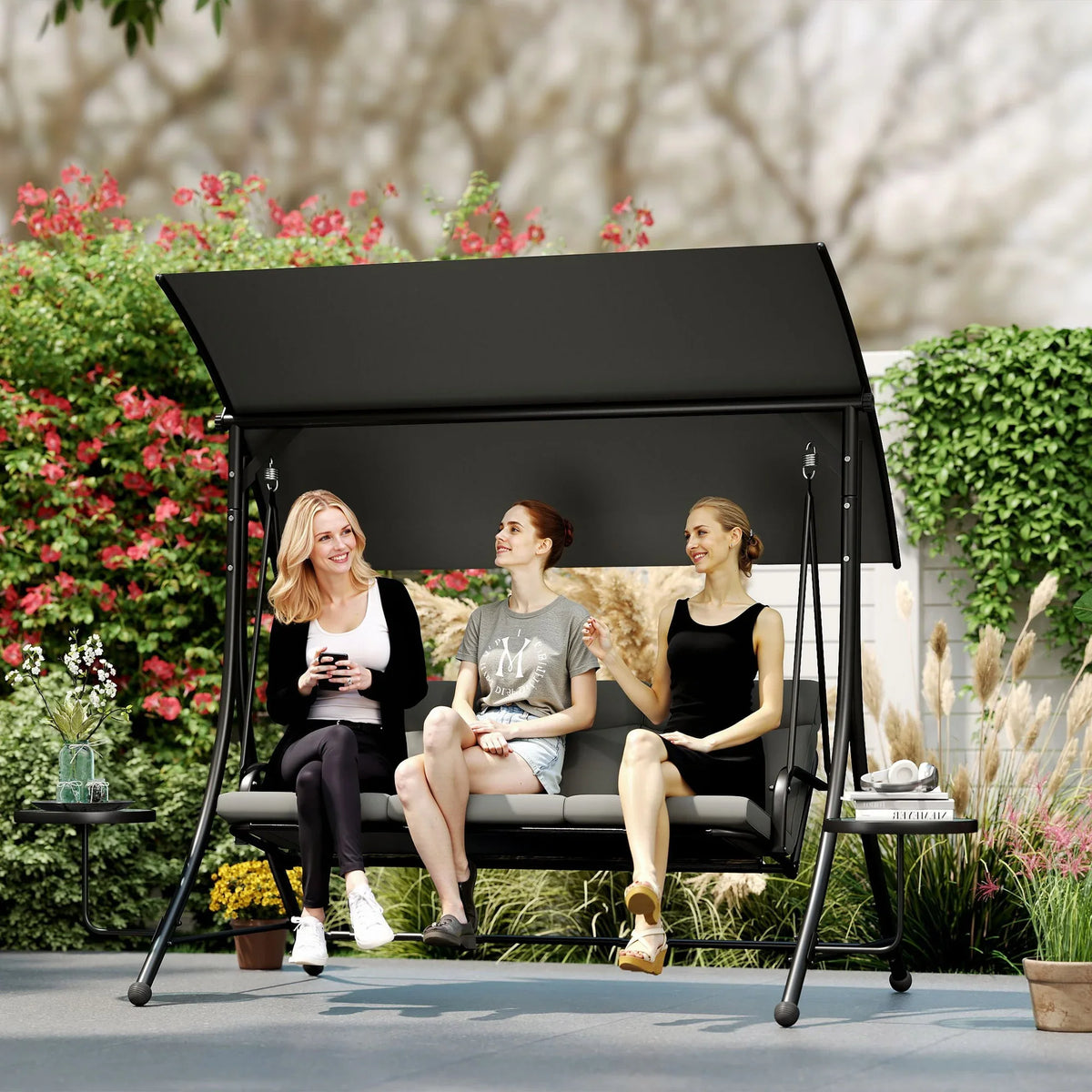 Three-seater garden swing with dark canopy, grey cushions, and curved armrests