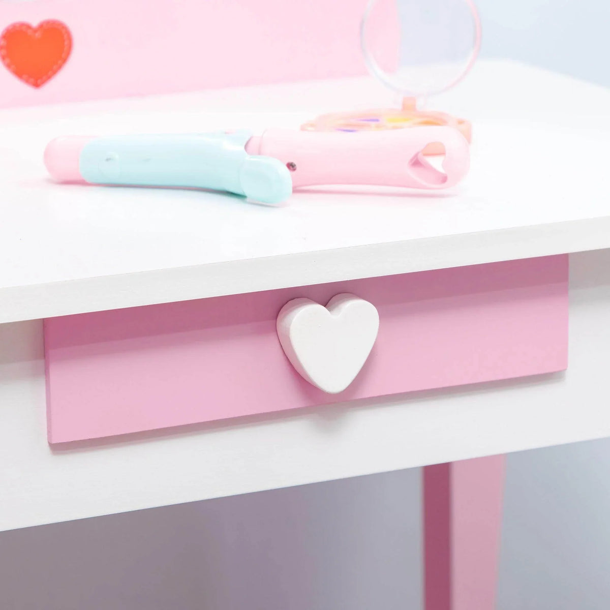 Pink vanity table with heart-shaped shelf and drawer beneath the tabletop
