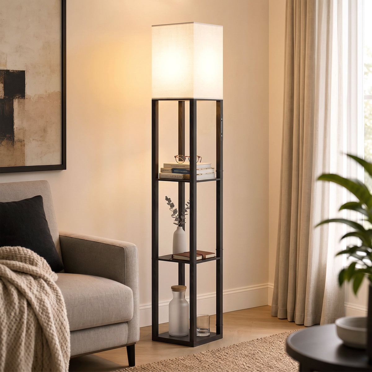 Black floor lamp with glass shelves and fabric shade, warm glowing light