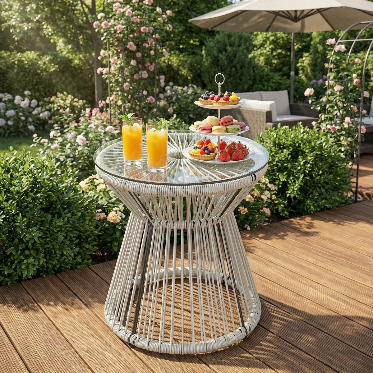 Light grey rattan outdoor coffee table with round tempered glass top and tiered base