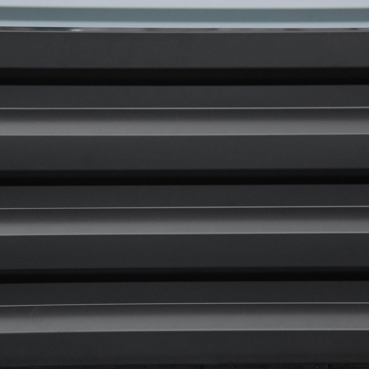 Dark grey slatted metal panel from a raised garden bed planter box