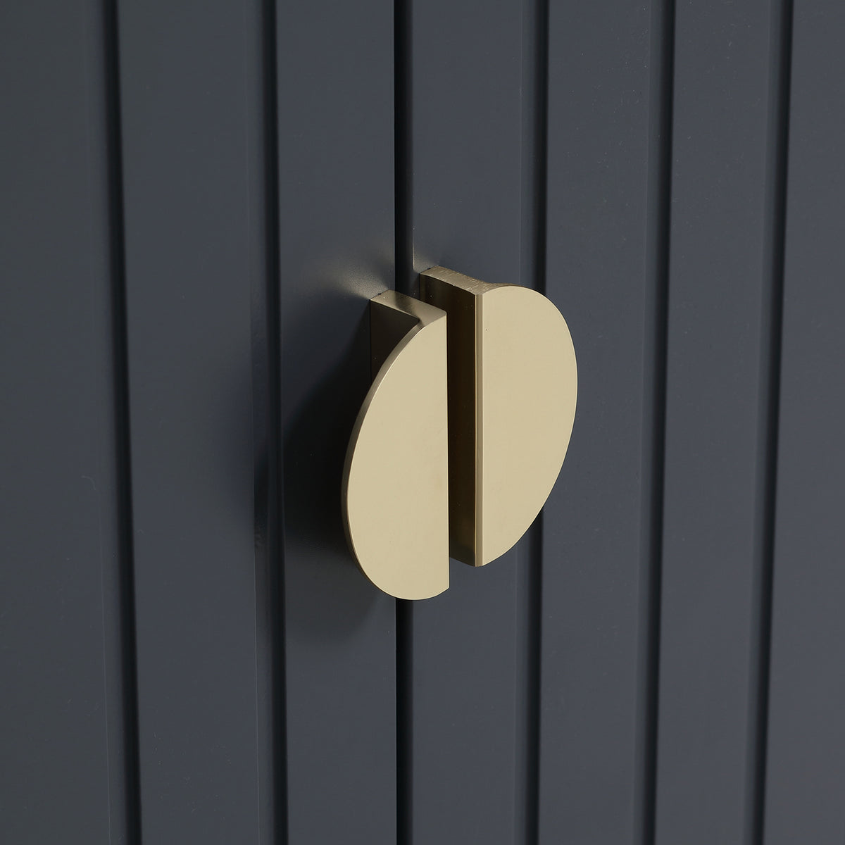 Grey shoe cabinet door with round gold pull handle on vertical ribbed panel.